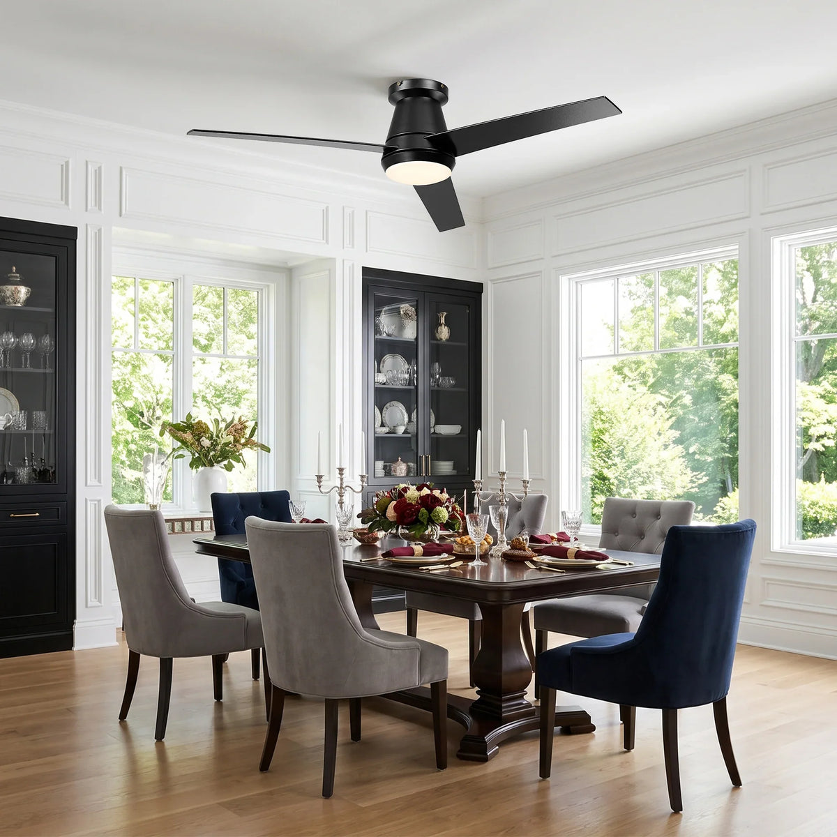 Modern black three-blade ceiling fan with integrated light fixture in a dining room.