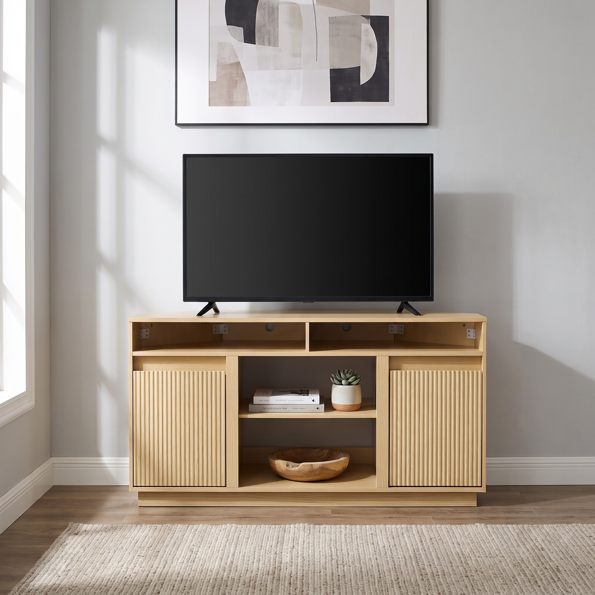 Modern light wood TV stand with fluted doors and open shelving under a flat-screen TV.