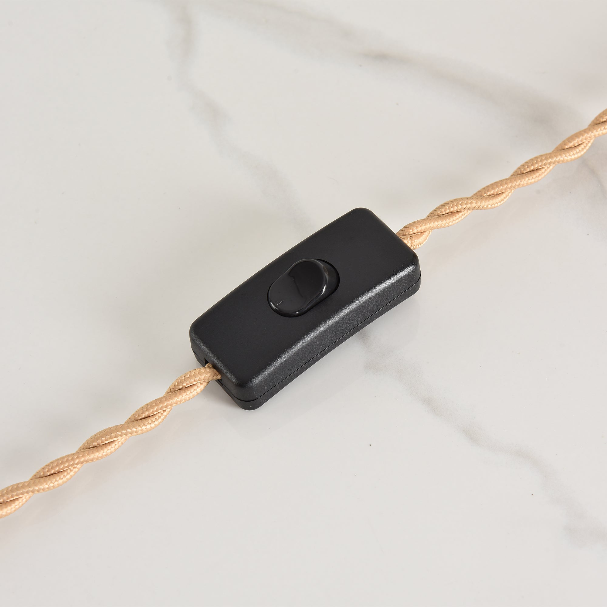 Black inline power switch on a twisted beige fabric electrical cord