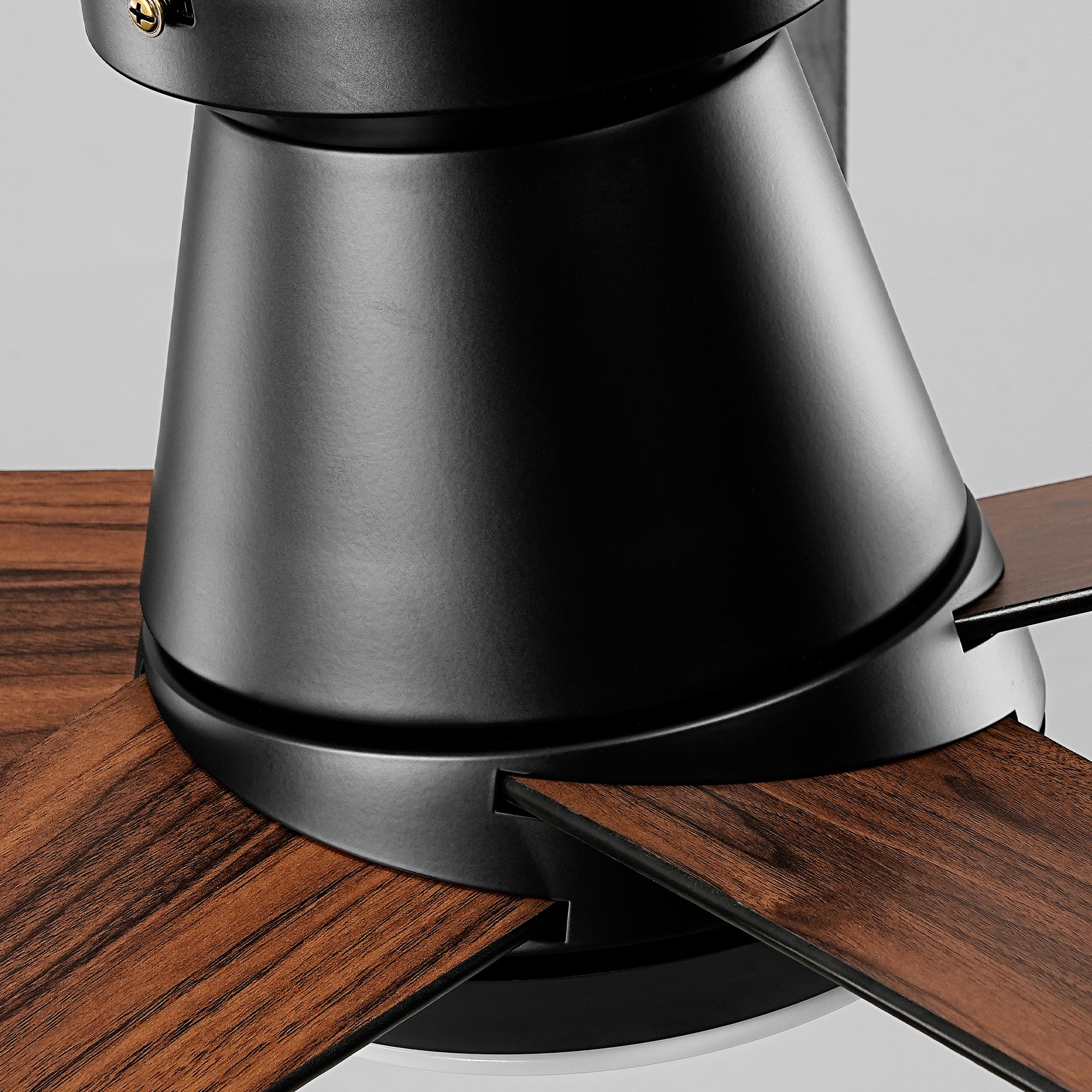 Close-up of a modern black ceiling fan with dark wood grain blades.